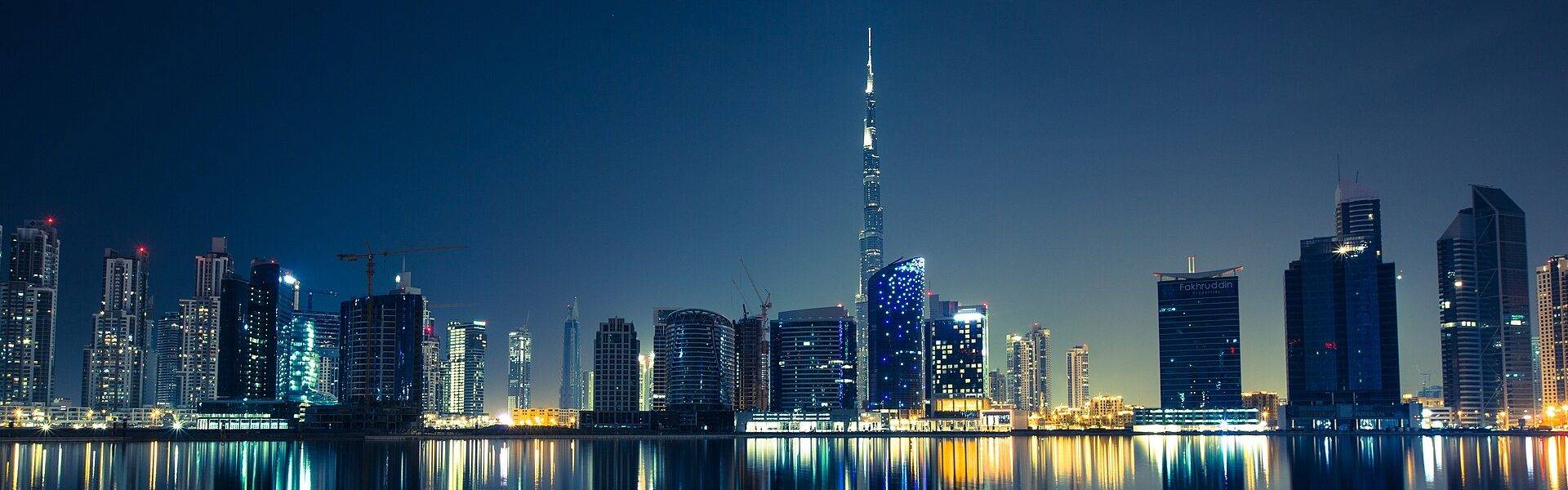 Dubai skyline at night reflected in the water